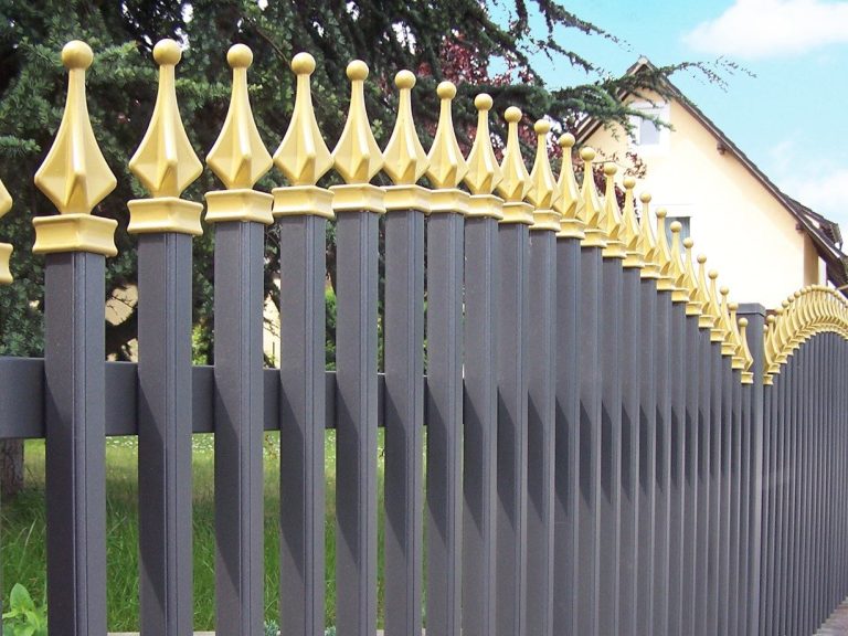 Metallzaun mit goldenen Aufsätzen